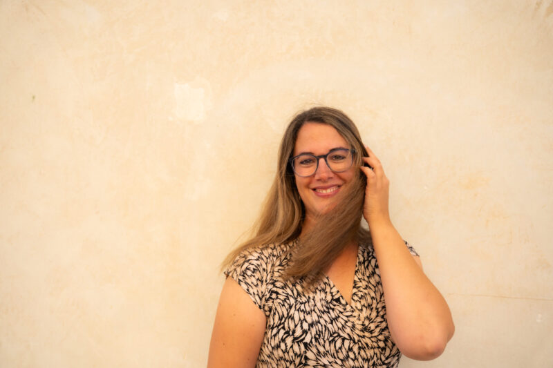 Melanie-im-Kleid-mit-Hut-lächelt-in-die-Kamera