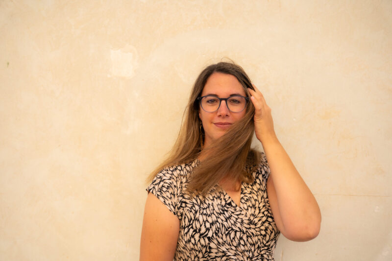 Melanie-im-Kleid-mit-Hut-schaut-in-die-Kamera