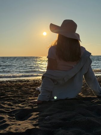 Melanie schaut am Strand in den Sonnenuntergang