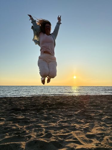 Melanie springt am Strand freudig