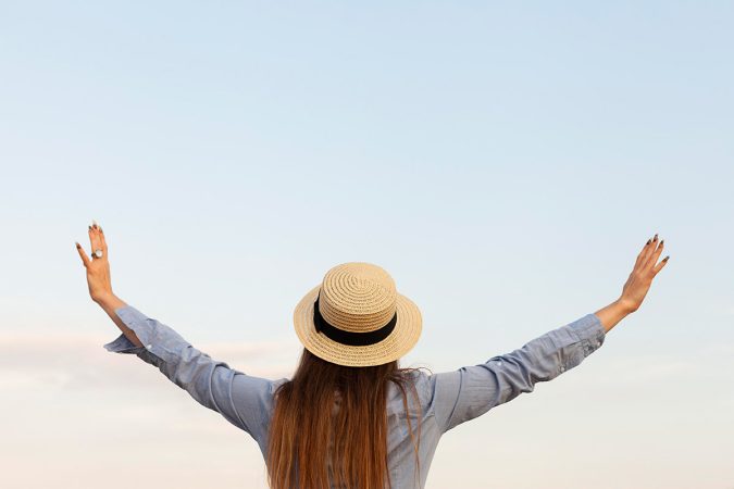 back-view-woman-with-posing-outdoors-with-arms-open