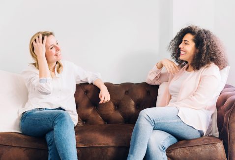 cheerful-women-talking-sofa cheerful-women-talking-sofa